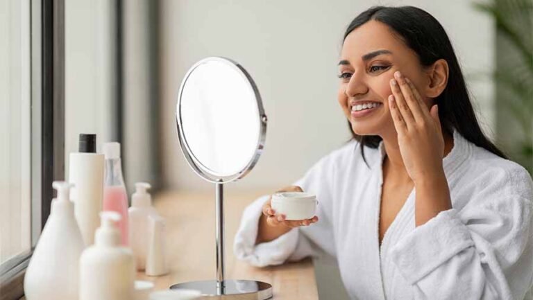 A women using sitting in front of the mirror and using cosmetics